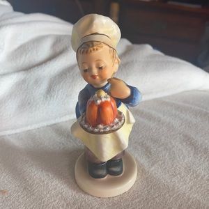Hummel Figurine #128 the “Baker” Boy eating a cake on a tray with baker hat